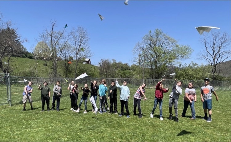 Students throwing paper airplanes